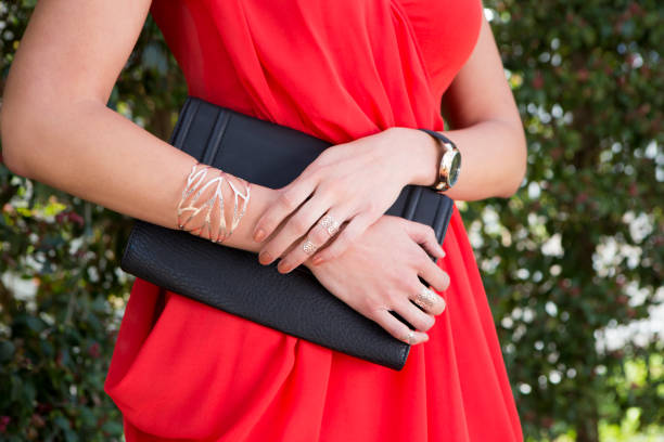 Stylish clutch purse paired with off-the-shoulder dress for a formal look.
